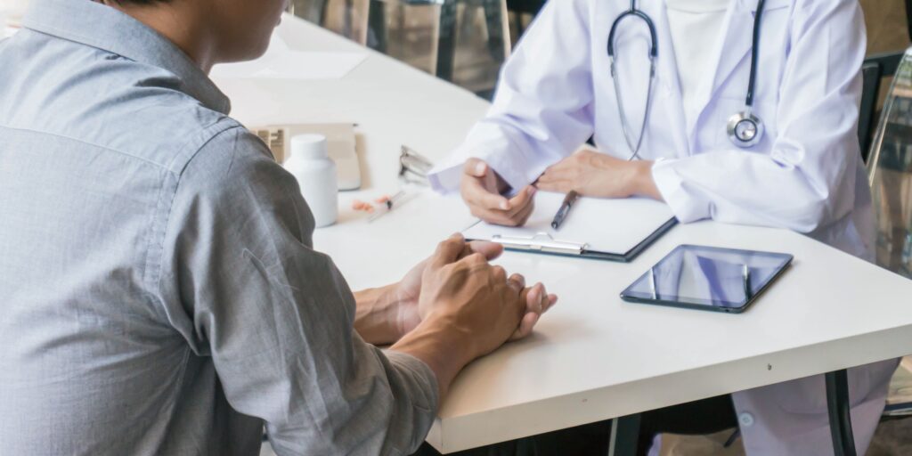 Warum eine Reiseversicherung immer sinnvoll ist – und wann sie wirklich zahlt Freundebuch Banner Medium US Querformat Arztgespräch zwischen Patient und Arztlche Reiseversicherung wenn man krank wird im Urlaub Reiseversicherung