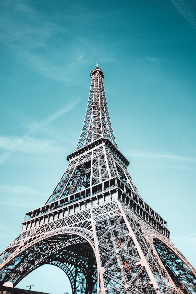 Stunning low angle view of the Eiffel Tower against a bright blue sky in Paris.
