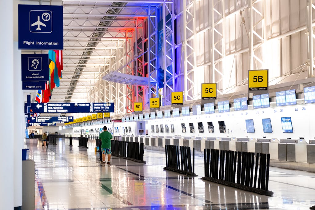 Flug verspätet? So forderst du jetzt deine Entschädigung richtig ein wide view of chicago airport terminal showcasing architecture and check in counters. flags and signages add vibrant detail. 2574078 Moderne Flughafenhalle mit Check-in-Schaltern.