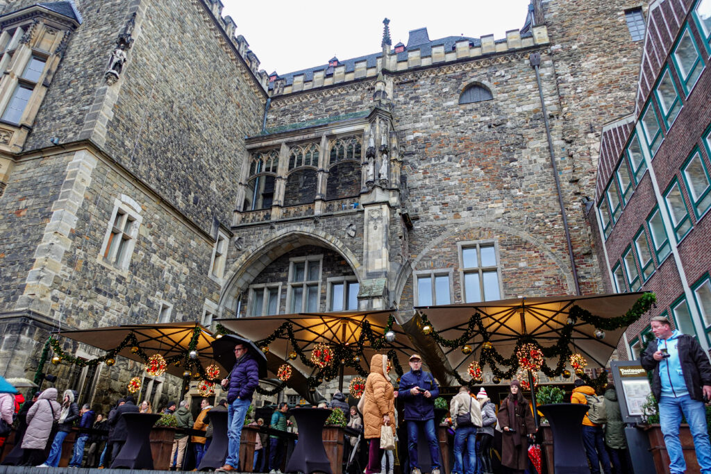 Weihnachtsmarkt in Aachen mit Blick auf die historischen Fachwerkhäuser und dekorierten Ständen am Abend.