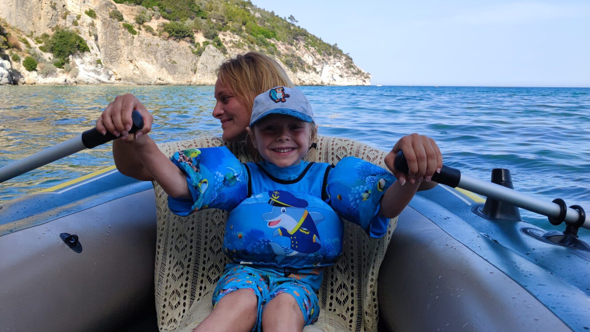 Mutter und Kind auf einem schlauchboot in Italien am Meer