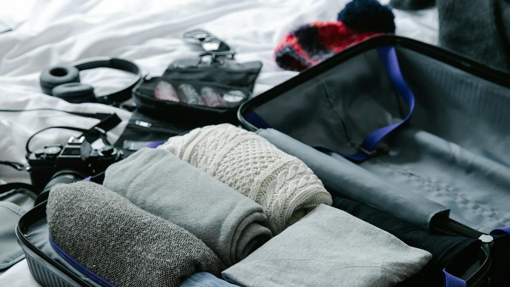 Reise Must Haves: 15 Dinge die im Urlaub nicht fehlen dürfen open suitcase filled with neatly folded clothes on bed ready for travel preparation. 9186152 scaled edited Reise Must Haves: 15 Dinge die im Urlaub nicht fehlen dürfen