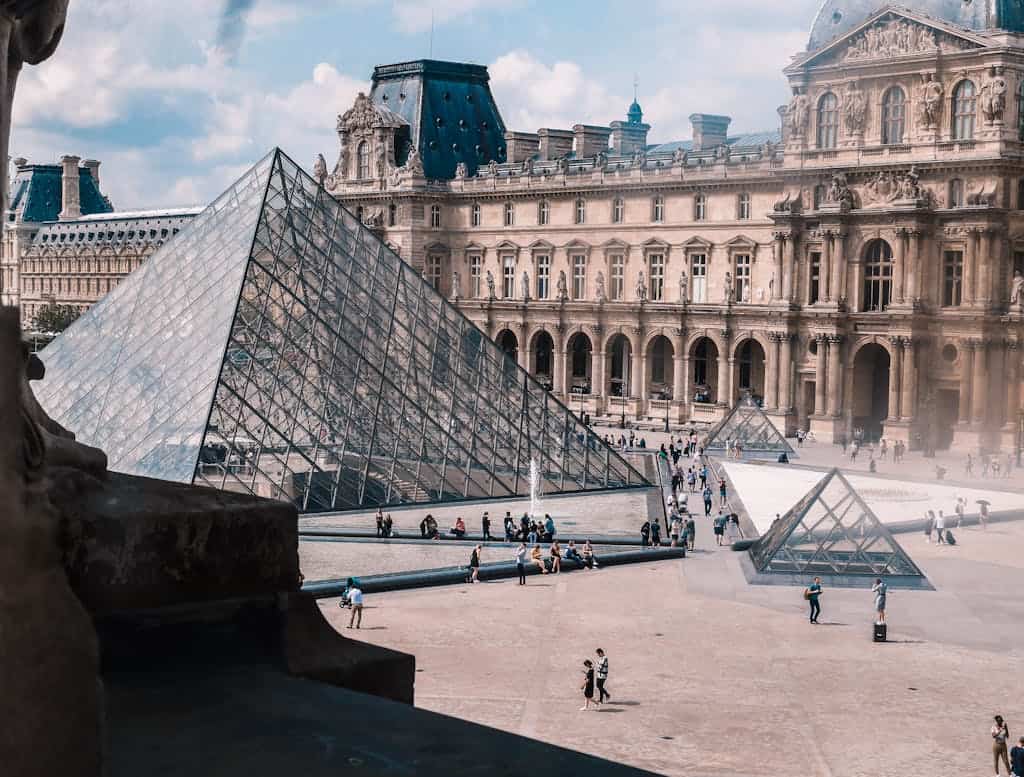 Louvre Museum mit Glaspyramide in Paris, Frankreich, bei Tag.