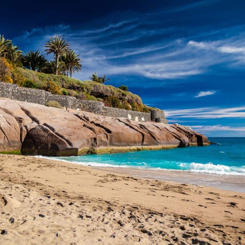 Die schönsten Strände auf Teneriffa – schwarze Sandstrände & versteckte Buchten Playa del duque teneriffa erfahrung schoenste straende Heller Sandstrand Playa del Duque an der Costa Adeje auf Teneriffa mit klarem Wasser und gepflegter Promenade