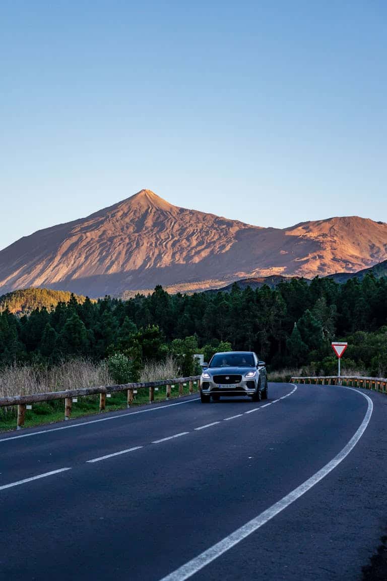 Mietwagen auf Teneriffa – lohnt sich ein Auto wirklich? car on a curvy road with mount teide in the background during daylight in tenerife spain. 14809946 Auto fährt auf kurviger Straße vor beeindruckender Bergkulisse.