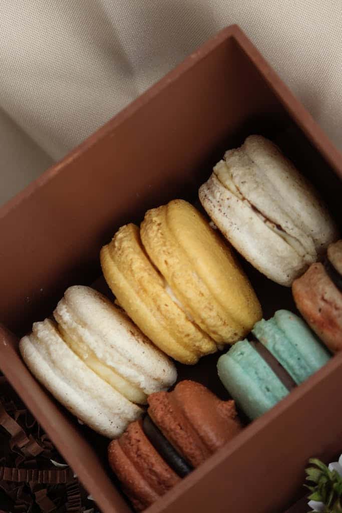 Close-up shot of colorful macarons in a brown gift box, perfect for dessert inspiration.