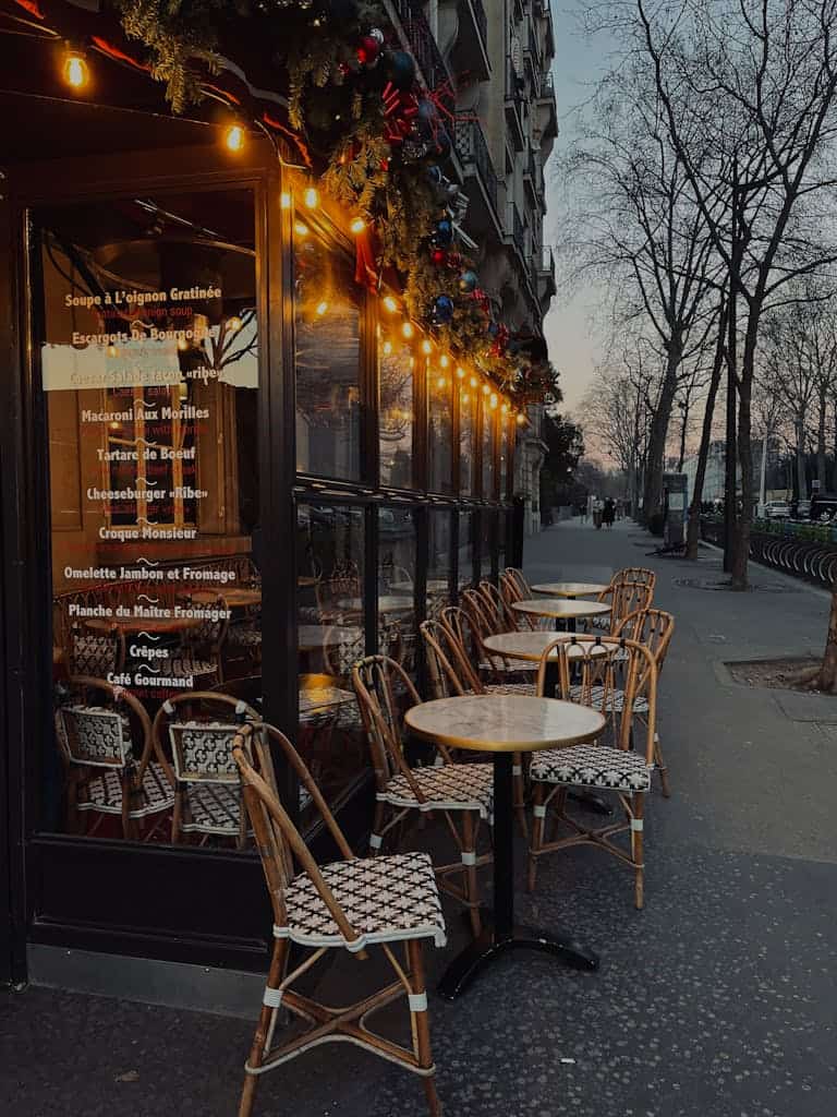 Cozy outdoor seating of a Parisian café at sunset. Ideal for travel and urban themes.
