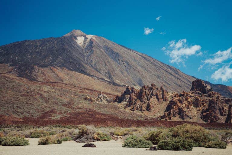 Dramatic view of Mount Teide in Tenerife with clear blue skies, showcasing volcanic landscape.