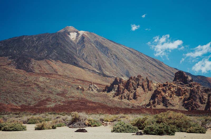 Dramatic view of Mount Teide in Tenerife with clear blue skies, showcasing volcanic landscape.