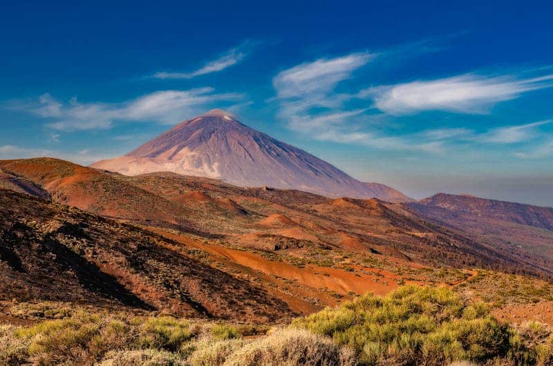 Vulkanlandschaft in Tansania mit aktivem Vulkan und umliegender Natur.
