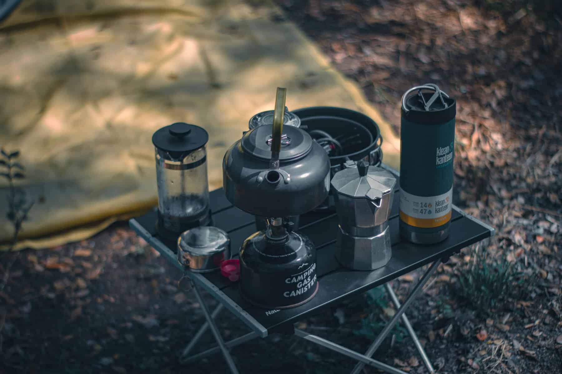 Camping-Ausrüstung: 50 geniale Dinge, die jeder Camper braucht a cozy camping setup featuring coffee making equipment and a tent outdoors. 8626740 scaled Camping Ausrüstung und praktische Camping Gadgets für Zelt, Wohnwagen und Camper