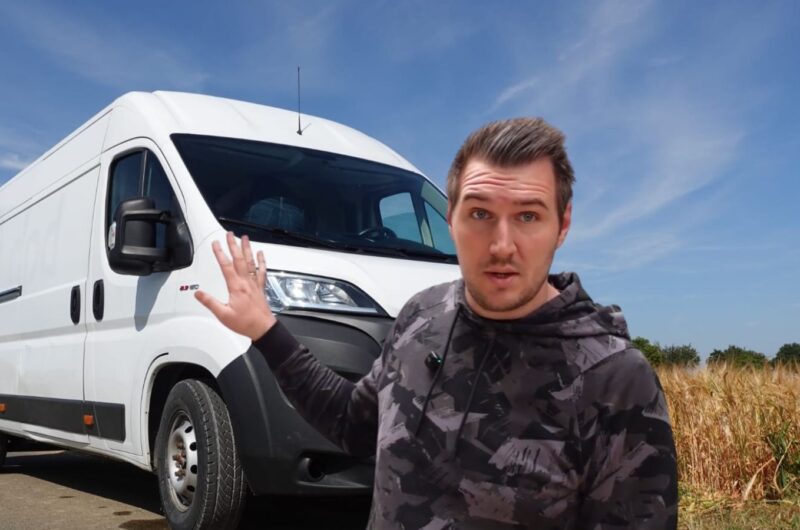 Mann zeigt auf weißen Lieferwagen.