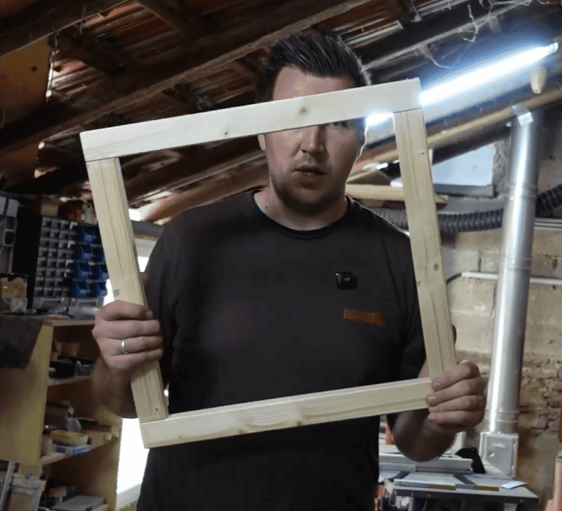 Dachluke im Fiat Ducato einbauen: So haben wir das Dachfenster in unseren Camper gesetzt rahmen dachfenster bauen Mann hält Holzrahmen in Werkstatt