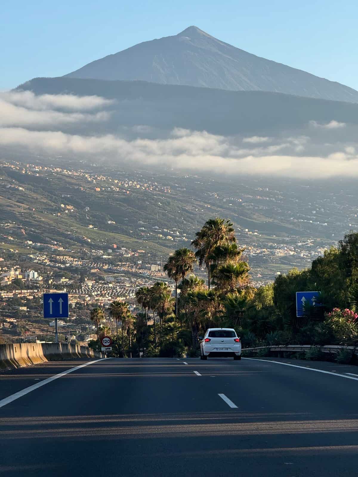 Mietwagen auf Teneriffa: Lohnt sich ein Auto wirklich? a picturesque drive towards mount teide in tenerife framed by lush greenery and morning clouds. 31167431 scaled Mietwagen auf Teneriffa: Lohnt sich ein Auto wirklich?