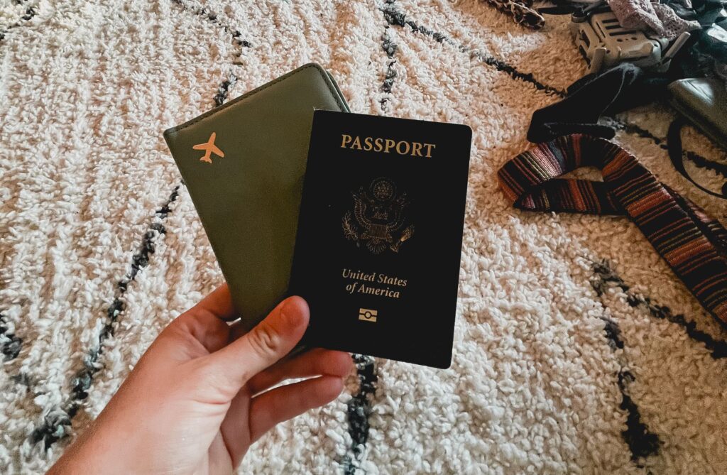 Welche Reiseversicherung brauche ich wirklich? Unser ehrlicher Überblick hand holding two passports on a patterned carpet indoors travel essentials. 28296762 scaled e1788882026752 Reisedokumente Checkliste: Diese 12 Unterlagen sind im Ausland Pflicht