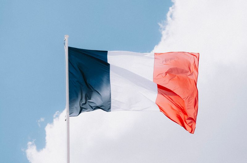 Reiseziele entdecken – unsere Reisen & Tipps & Inspiration the french flag waving in the wind set against a vibrant blue sky with clouds. 12467785 Beste Reisezeit für Frankreich